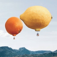 two oranges and a lemon flying in the air